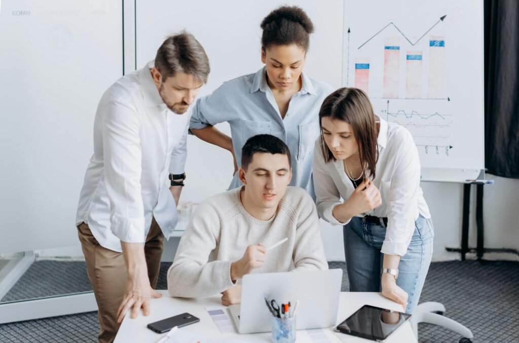 Group of professionals collaborating on a project with graphs in an office setting.